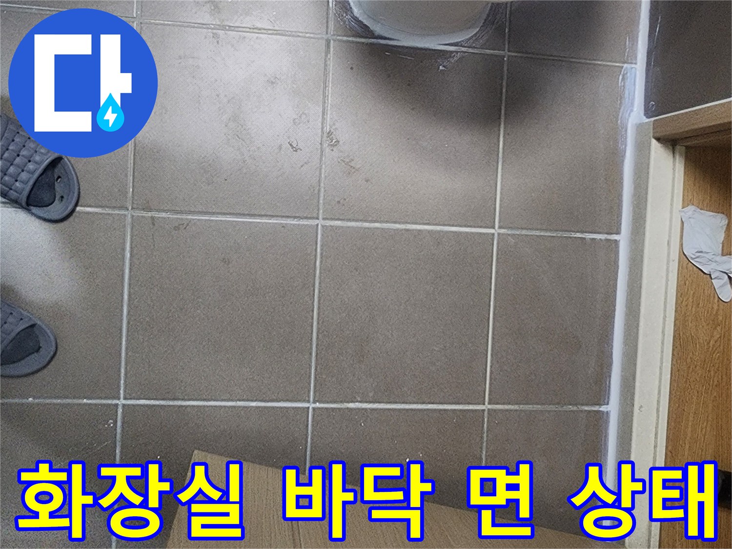 변기 밑부분과 타일 줄눈의 근접 촬영 사진입니다.