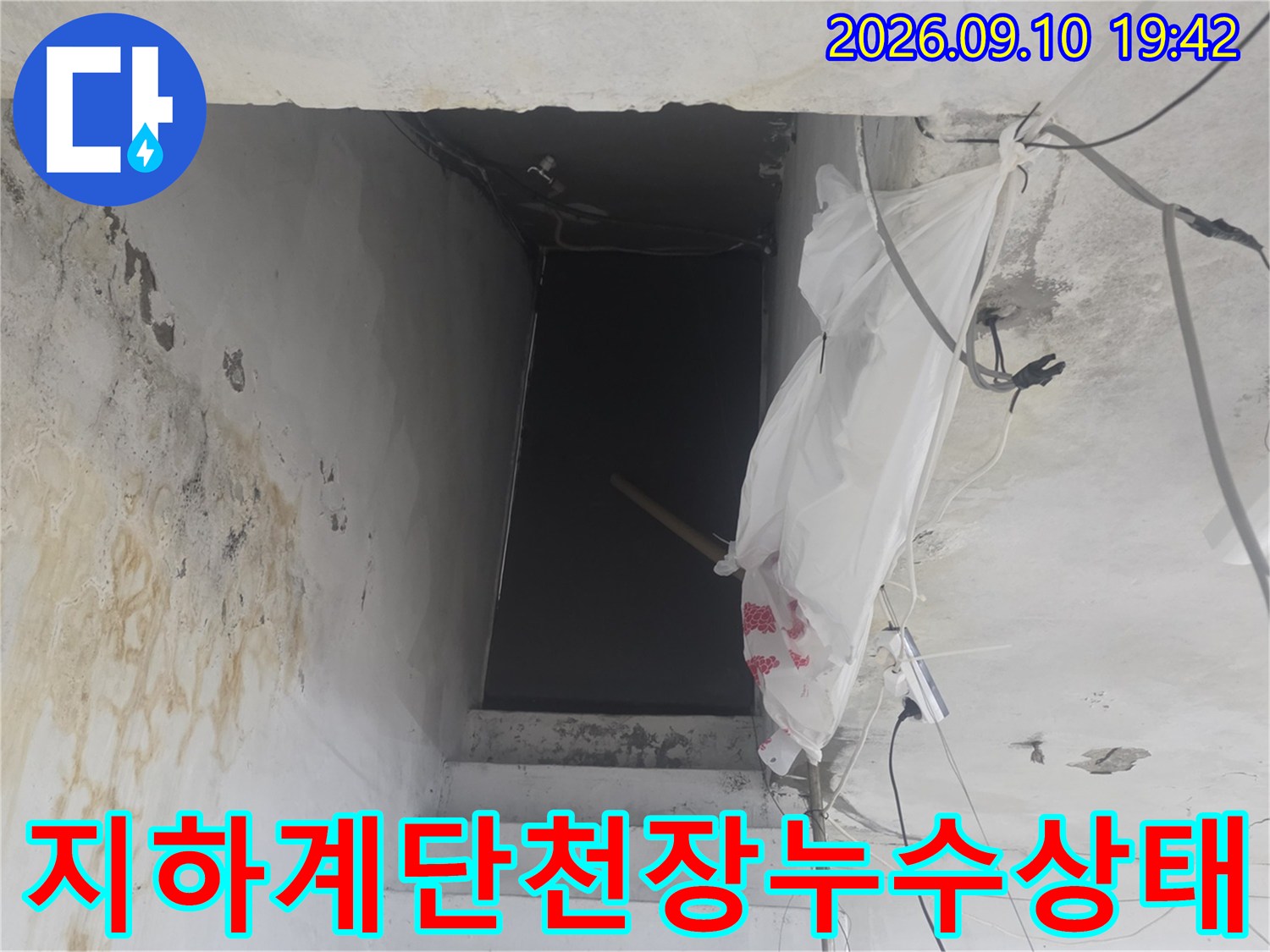 계단 천장 마감재 주변의 물샘 흔적과 배관 노출 부위