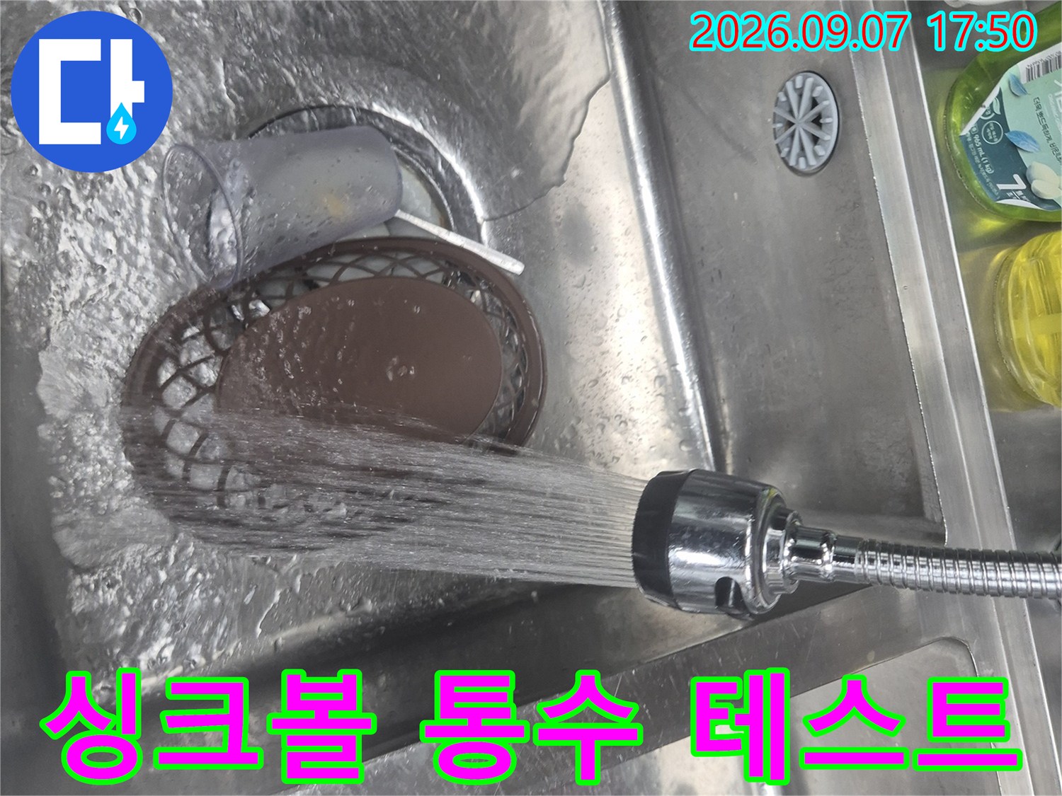 스테인리스 싱크대에 물을 틀어 배수 상태를 점검하고 있습니다.