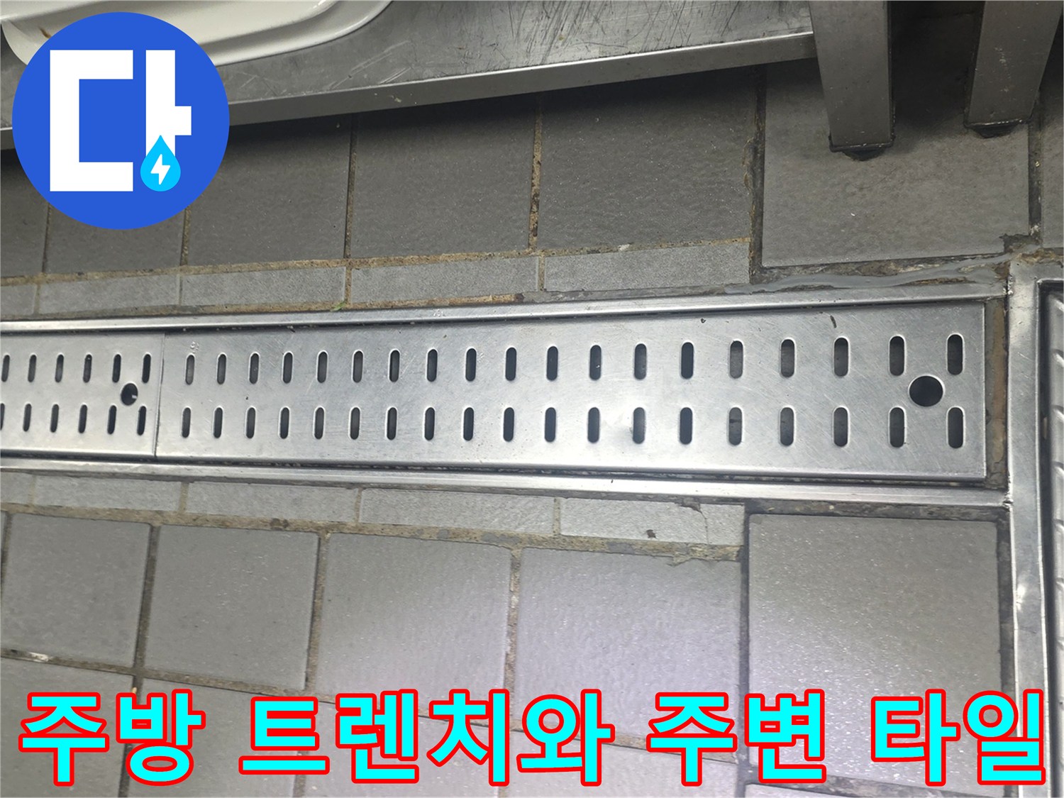 스테인리스 배수 트렌치와 회색 타일이 인접한 현장 사진