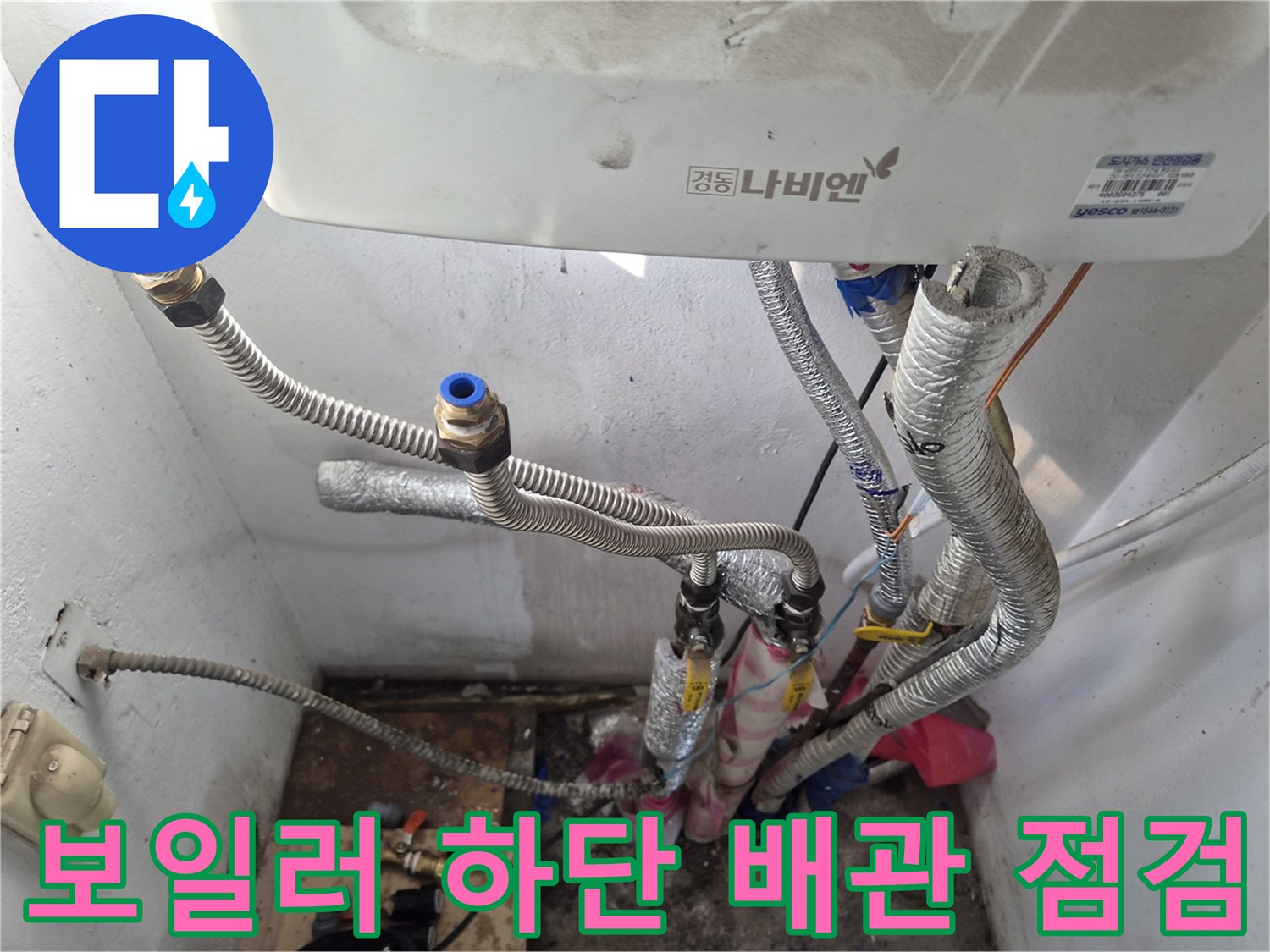 보일러-하단에-연결된-은색-주름관과-배관-부속품들-모습