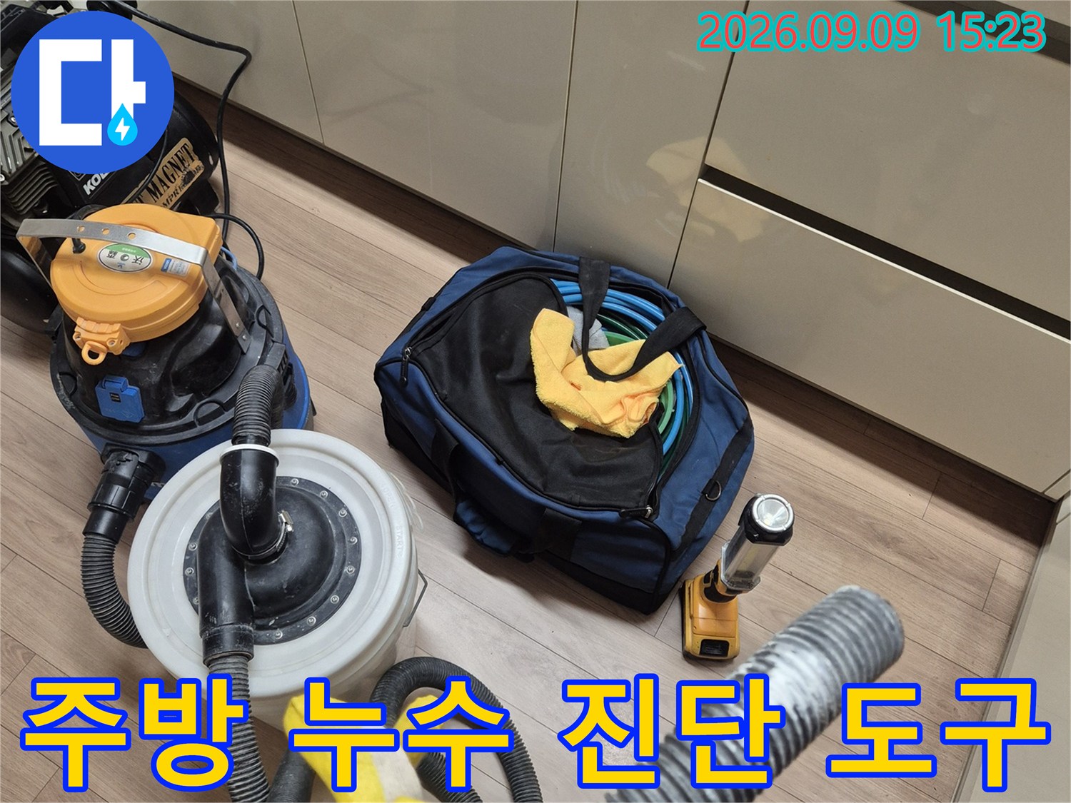 누수 지점을 찾기 위해 싱크대 아래에 세팅된 청소기와 공구들