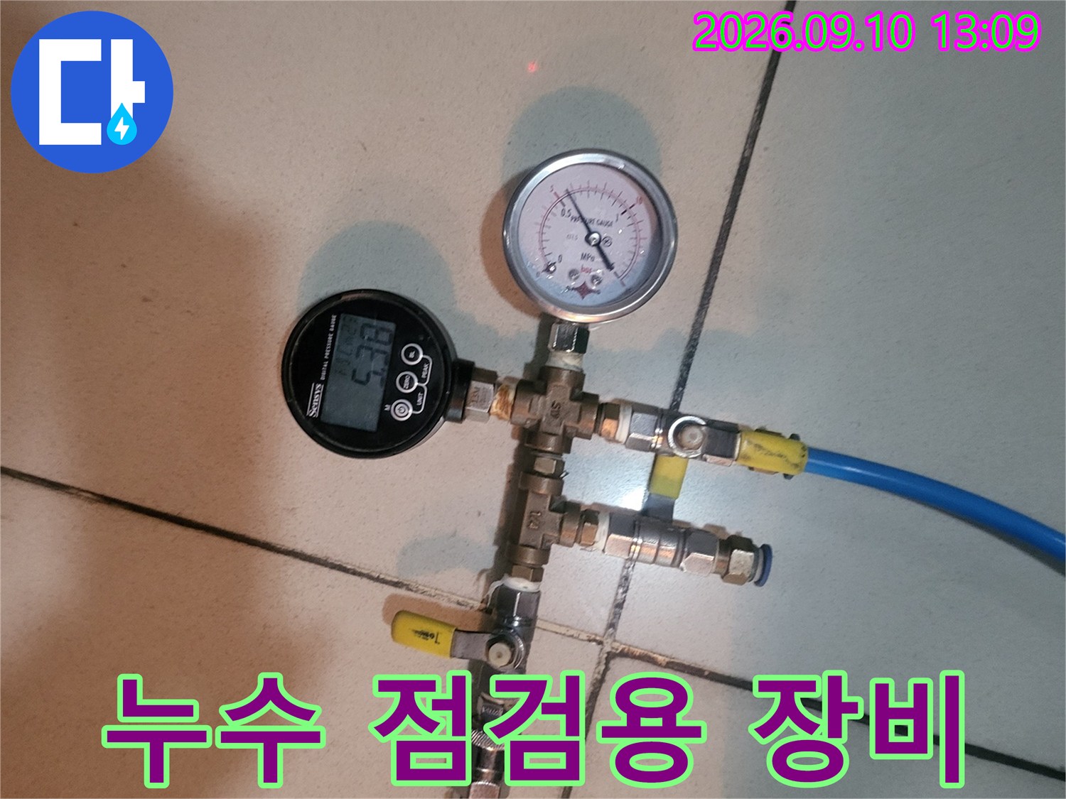 파란색 호스와 압력 게이지가 연결된 배관 검사 장치