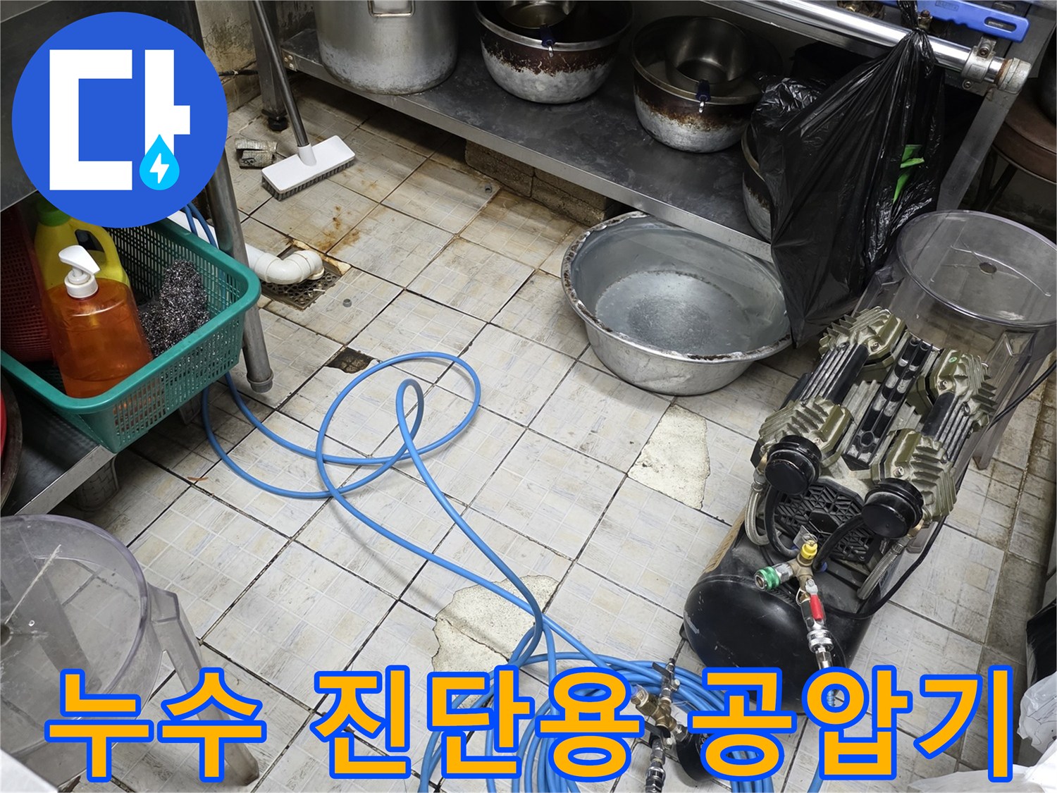 주방 조리 도구 옆에 설치된 누수 탐지용 압력 측정 장비와 호스