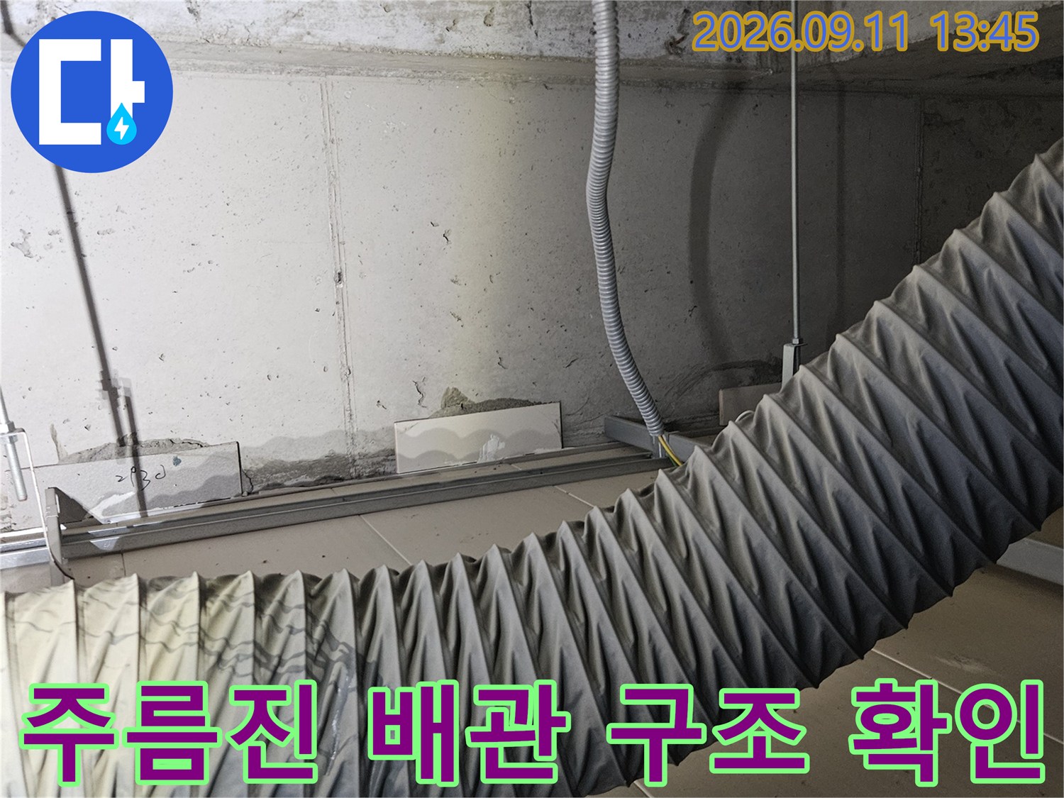 천장 공간에 설치된 굵은 주름관과 벽면 연결 배관의 상세 모습입니다.