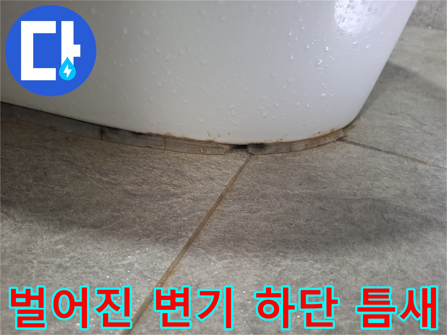 변기 도기와 타일 사이의 벌어진 틈을 근접 촬영한 사진