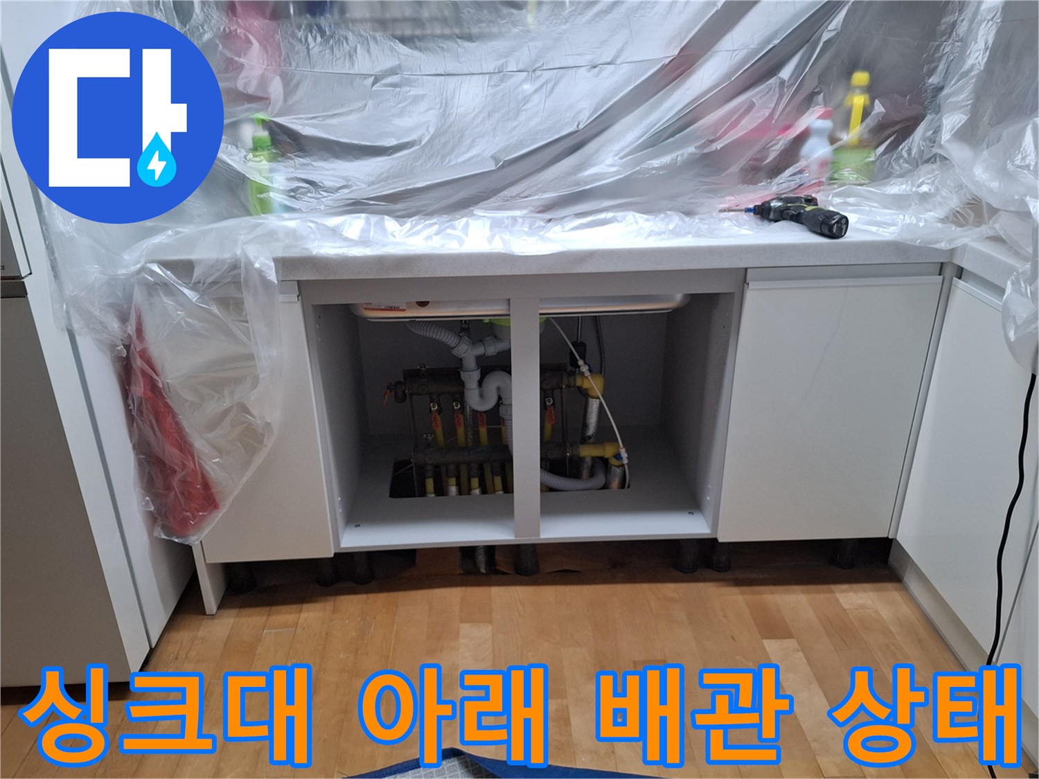 보양 작업 후 싱크대 하부장에 노출된 난방 배관 부속들