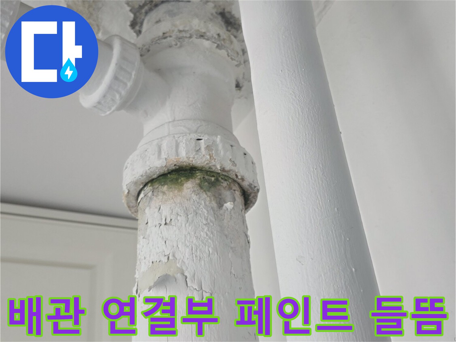 하얀색 배관-연결 부위 주변의 갈라지고 부풀어 오른 벽면 도장층