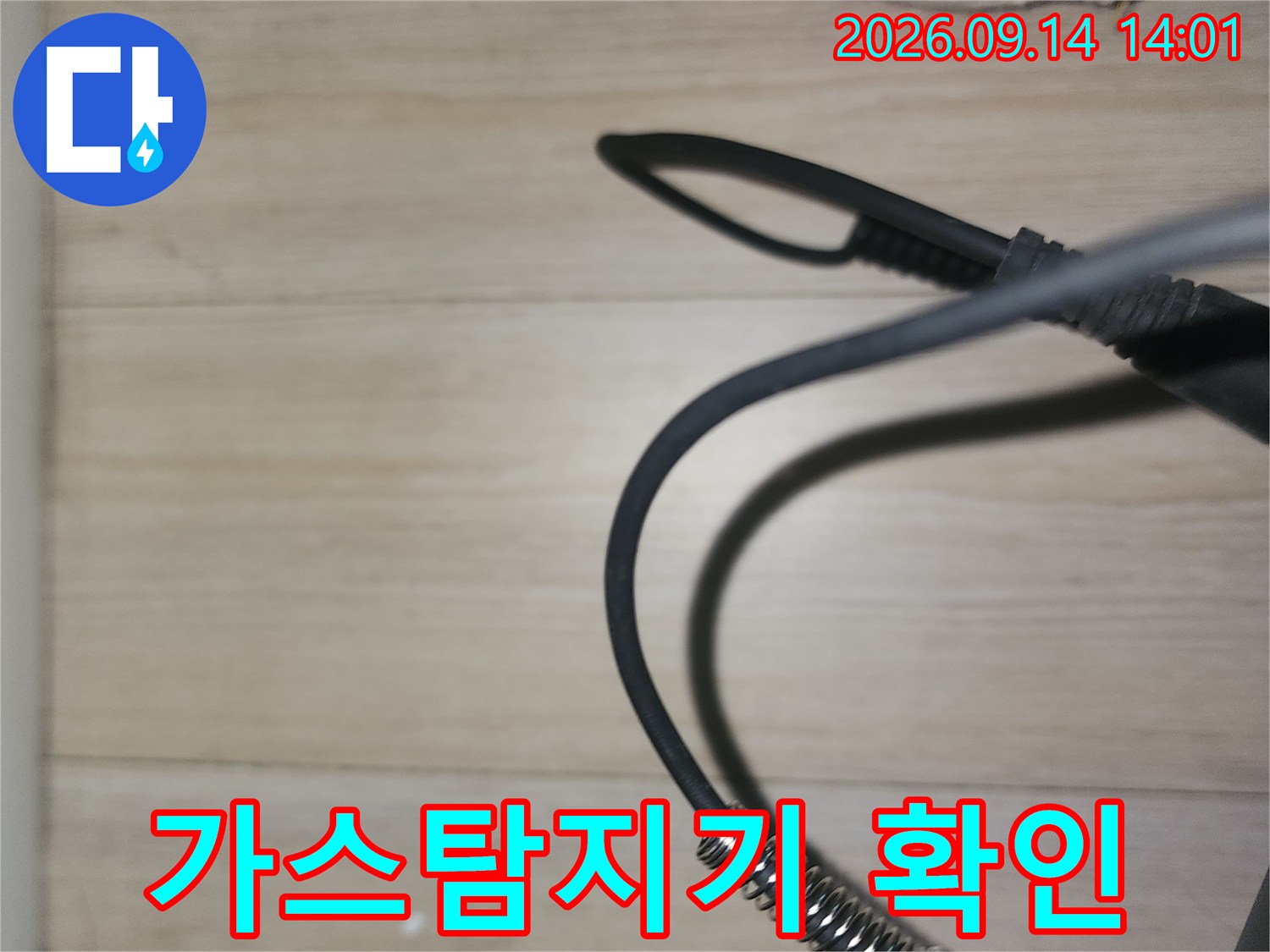 배관 누수를 찾기 위해 가스 탐지기를 천장에 대고 점검하는 모습