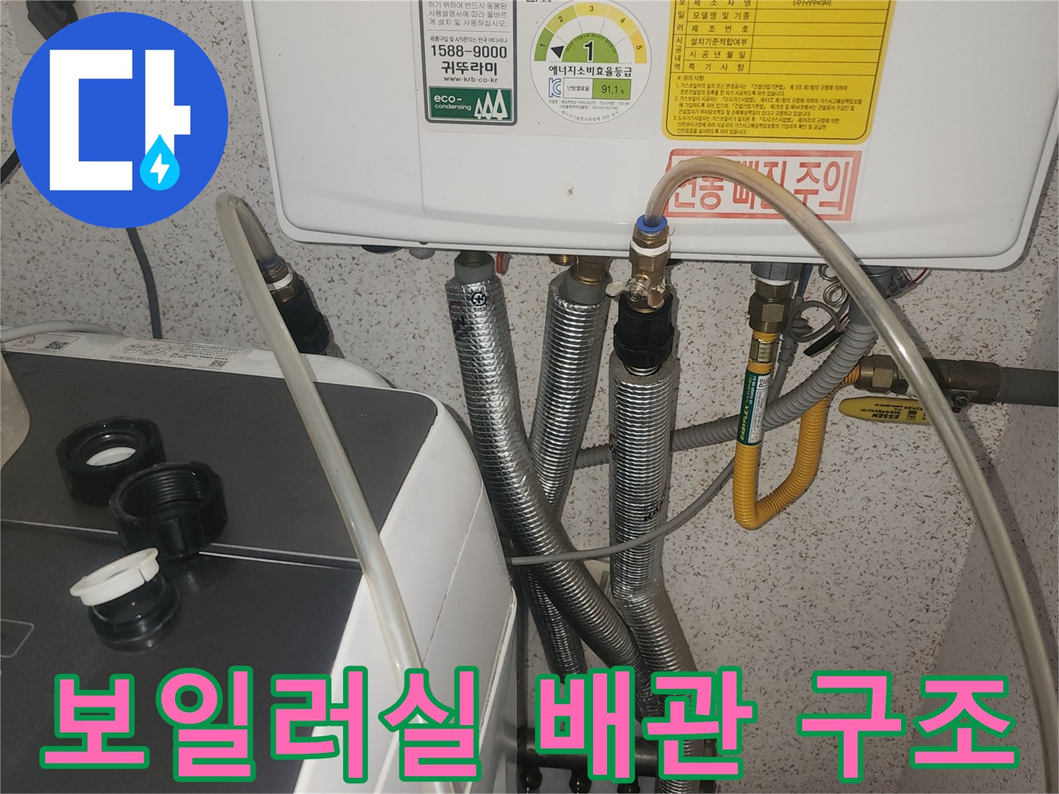 보일러 본체 아래로 연결된 여러 갈래의 배관과 호스들