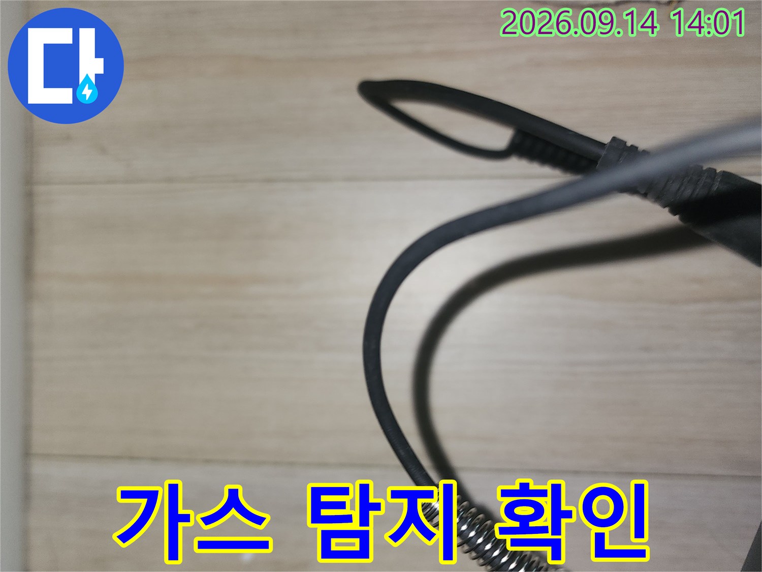천장 배관 부근에서 가스 누출을 감지하기 위해 작업 중인 손