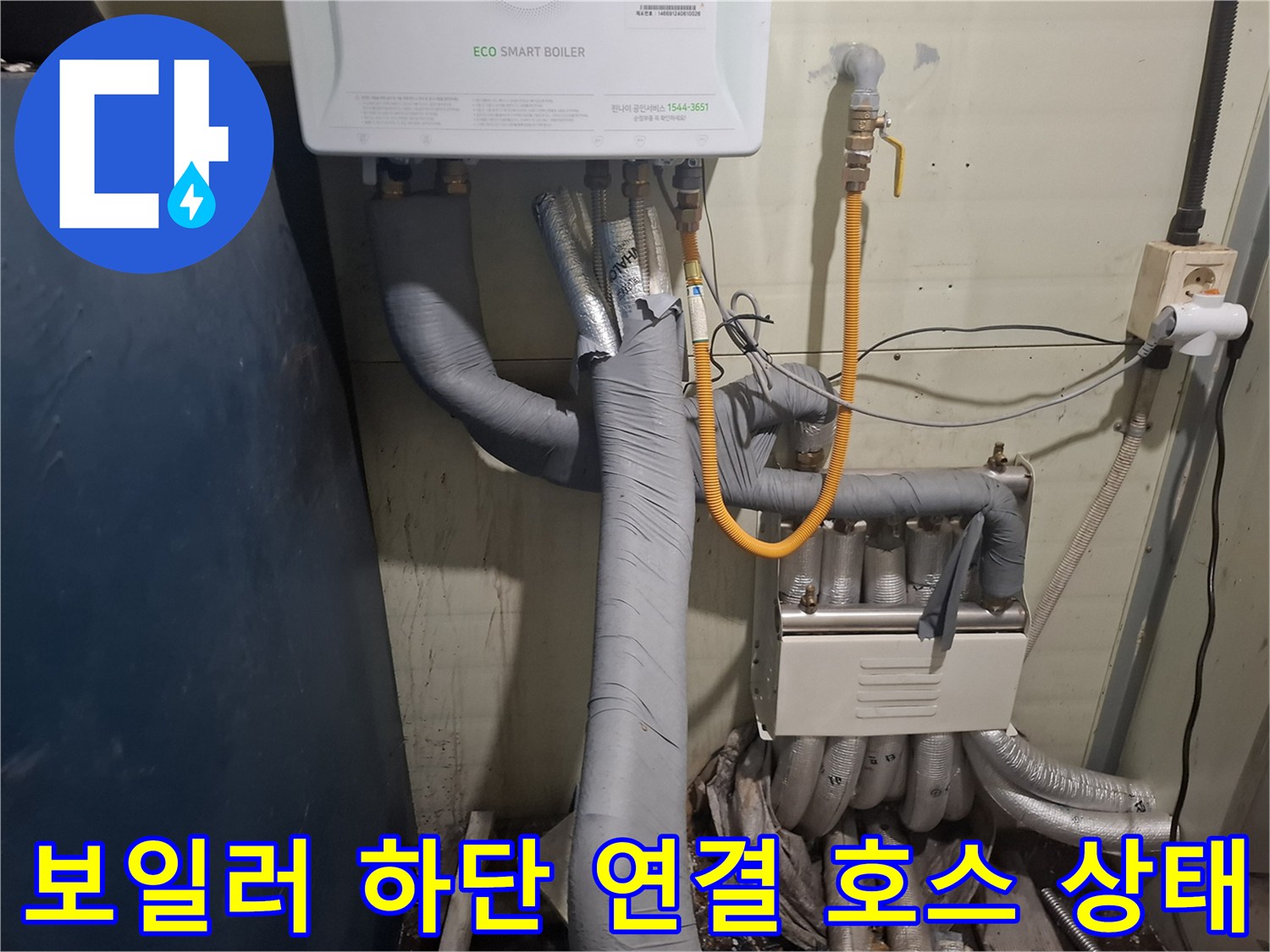 보일러 아래쪽의 노란색 호스와 회색 단열재 배관