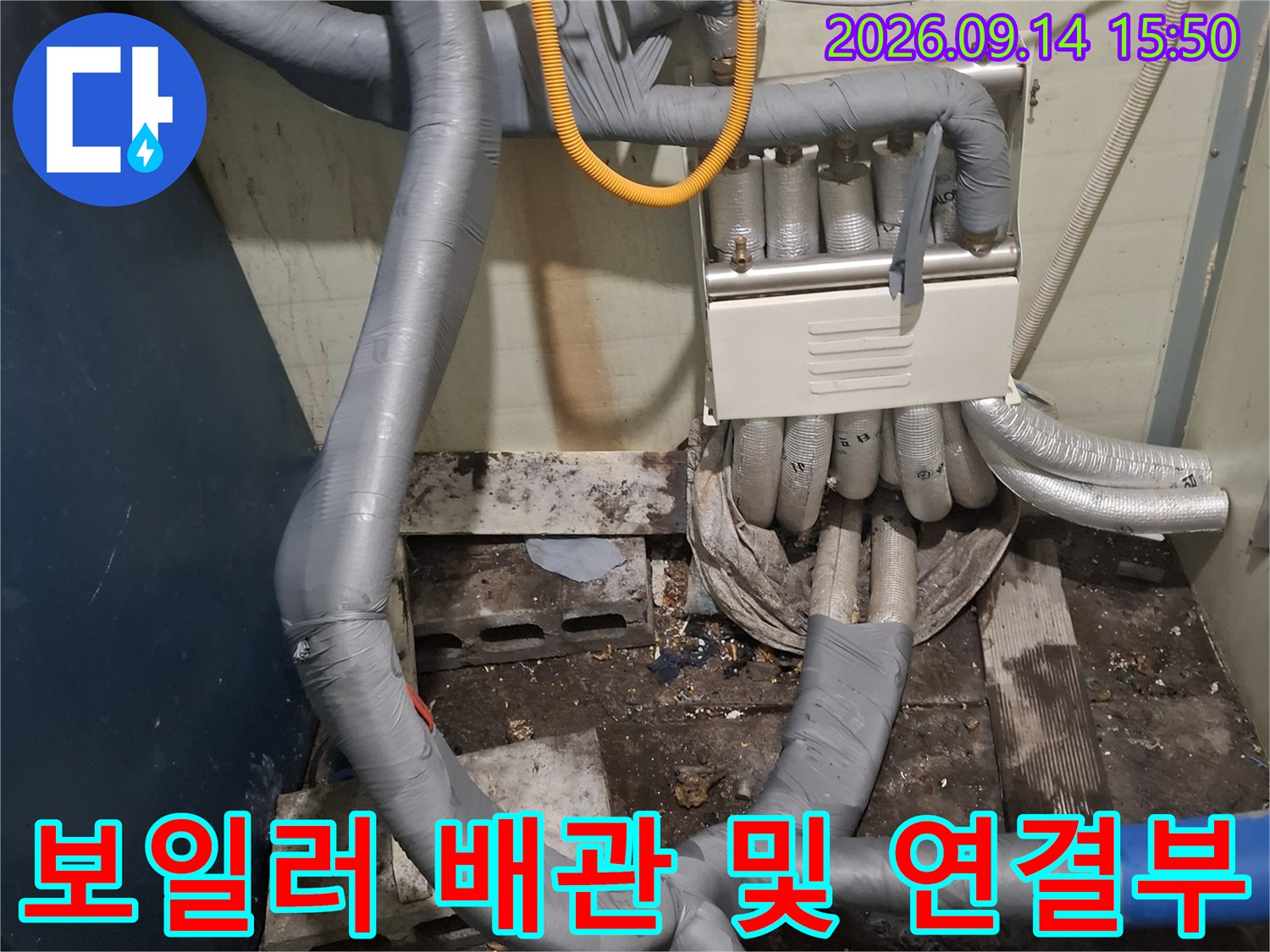 보일러 아래쪽의 복잡한 배관 구조와 보온재 작업 상태입니다.