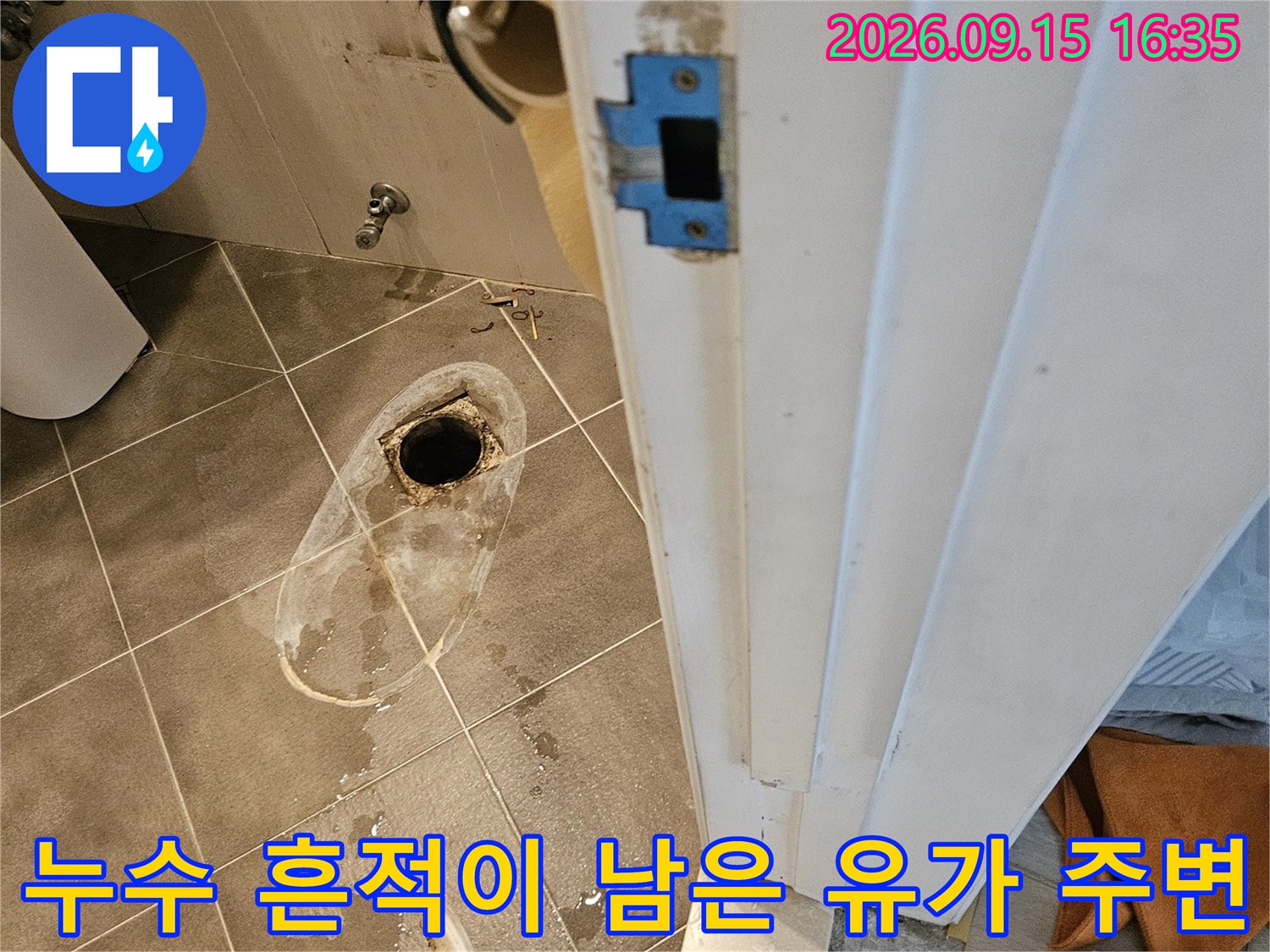 하얗게 얼룩진 배수구 주변 타일 바닥의 누수 현황 사진