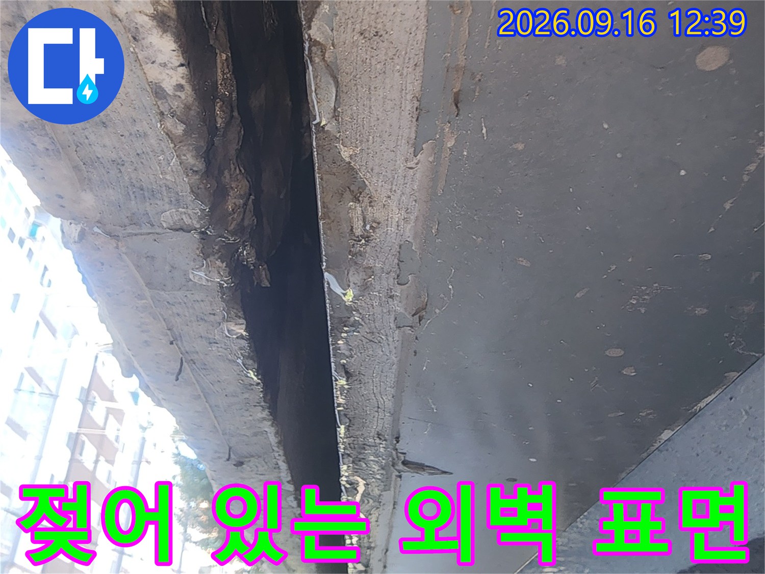 물기가 스며들어 어둡게 변한 건물 외벽 구조물