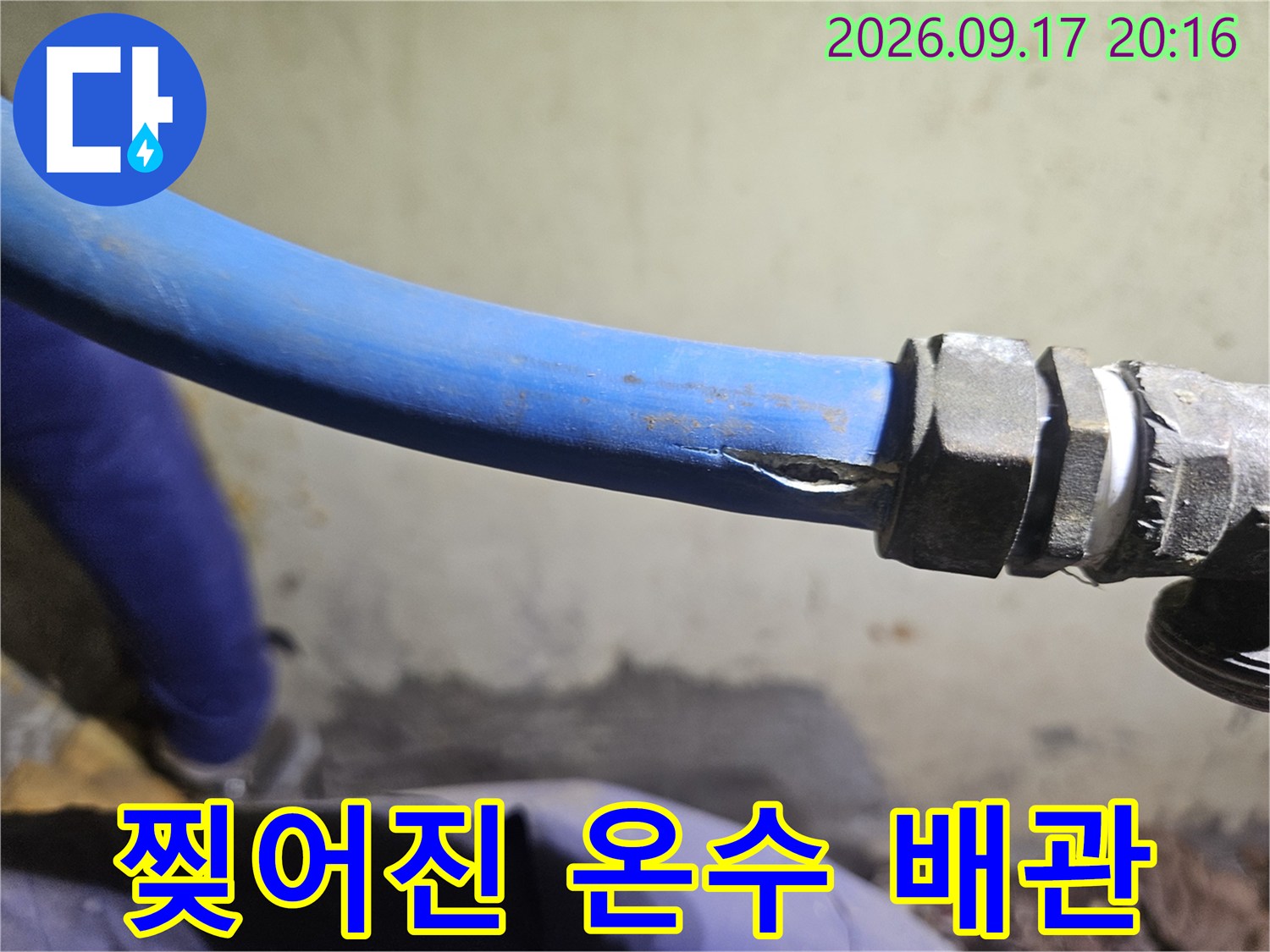 금속 부속과 연결된 파란색 배관의 찢어진 상태입니다.