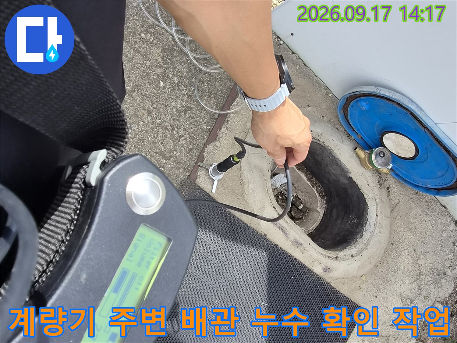 파란색-덮개가 있는 계량기 근처에서 배관의 누수 여부를 정밀하게 측정하고 있습니다.