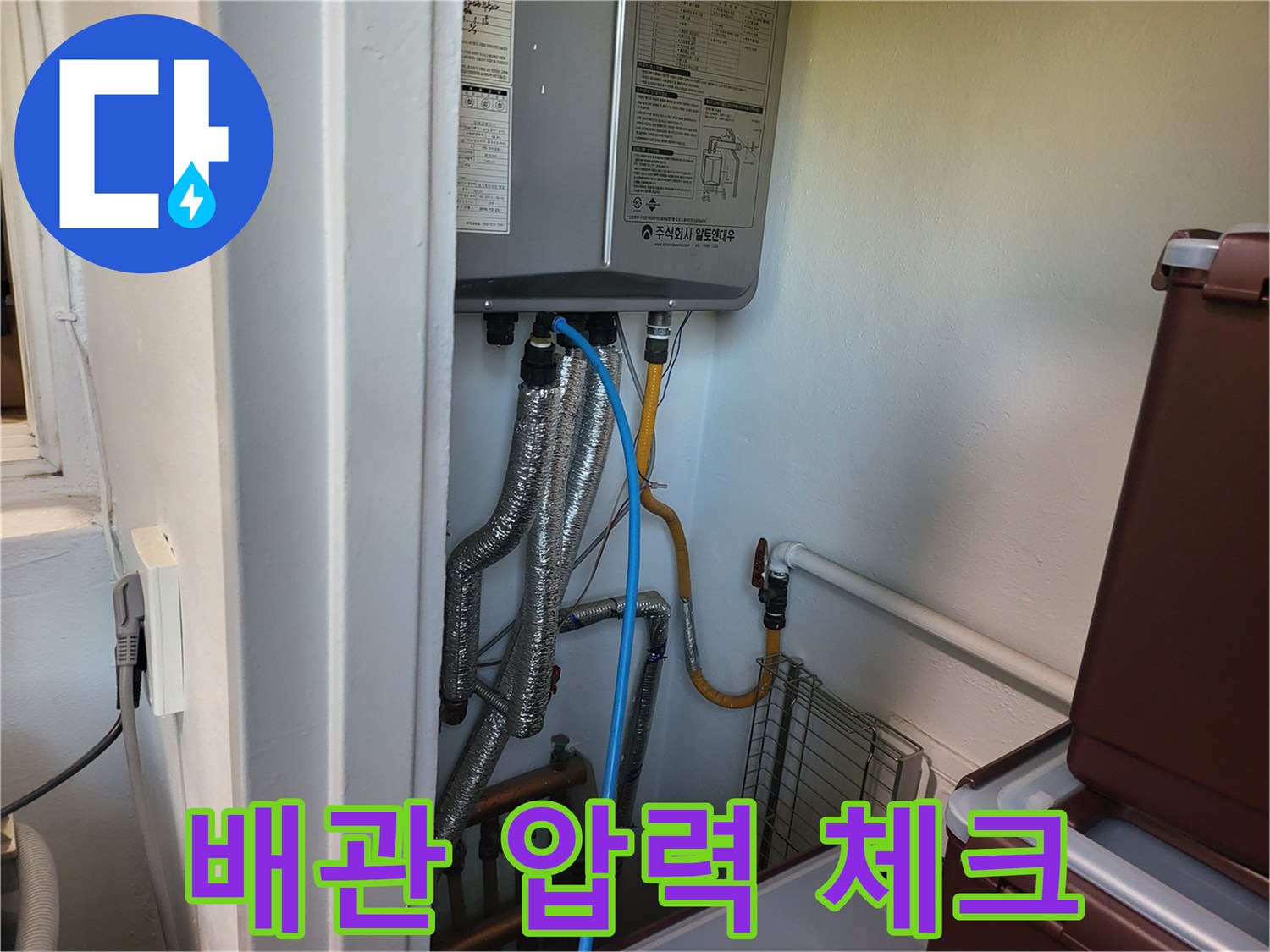 보일러 아래쪽 밸브와 배관에 테스트 장비를 연결하여 검사를 진행하는 사진입니다.