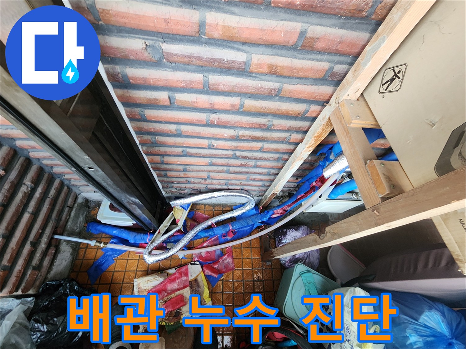 벽돌 벽 하단 배관의 보온재가 제거된 현장 모습 - 용정리